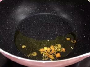 将辣椒洗净后切段放入锅中爆香