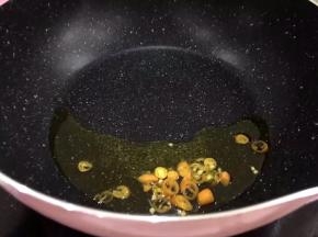 将辣椒洗净后切段放入锅中爆香