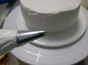 四周抹匀，先将原色奶油霜装入裱花袋