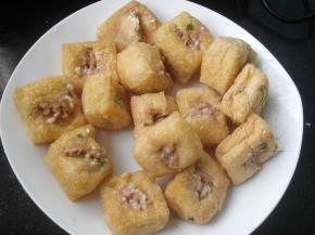 用筷子把油豆腐中间戳松，酿进少量肉末