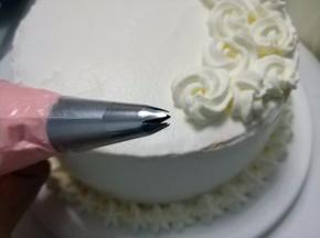 上面也挤上花型，再将原色奶油霜+粉色色素调匀，装入裱花袋