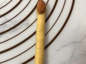 杏仁粘少许蛋液压在面团顶端，用线压出纹路。