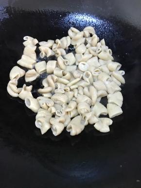 待油温升高，倒入肥肠。