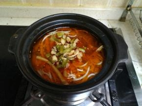 把酸笋和豆角倒入砂锅里.