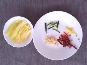将土豆洗净后去皮切丝用碗装起，泡水，将红尖椒洗净，切丝，大蒜洗净切碎，生姜洗净切丝，葱洗净切段