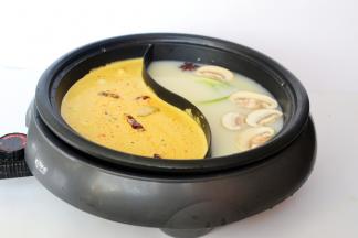 然后在红油汤这边加入调料，开火煮开就可以刷锅了。红油汤在加热过程中慢慢变红，一红一白搭配的火锅汤，让人食欲大开，你是否也看着流口水了呢？