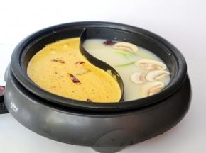 然后在红油汤这边加入调料，开火煮开就可以刷锅了。红油汤在加热过程中慢慢变红，一红一白搭配的火锅汤，让人食欲大开，你是否也看着流口水了呢？