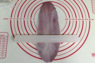 取一份包好的油酥皮，用擀面杖从中间往上往下各擀一下，不要反复擀，成牛舌即可。（油酥湿度够的话，就很容易擀开且不会出现白头，若有白头，也可以选择切掉白头的部分）