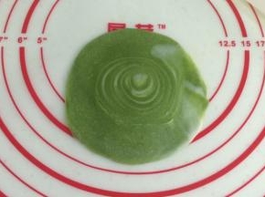 取一份切开的卷卷，用手掌压扁，再用擀面杖擀开，中间厚周围薄，中间的圈圈纹理部分尽量不要擀开。