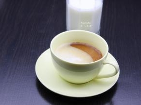 二分之一牛奶倒入咖啡杯中；