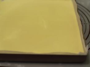 烤盘垫上油纸，倒入面糊，轻震几下