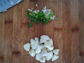 大蒜去皮，切个两刀，成块。小葱切段。