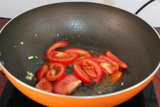 把切好的番茄块倒入锅中翻炒，加白砂糖炒软，变的多汁；