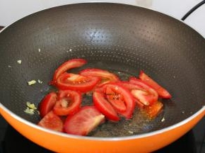 把切好的番茄块倒入锅中翻炒,加白砂糖炒软,变的多汁;