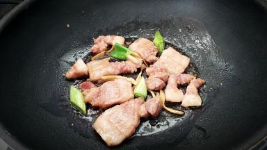 锅中放入油，放入葱，姜放入五花肉小火煎。