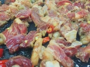 辣椒切碎，热锅下油，倒入辣椒炒香，倒入牛肉炒至变色关火