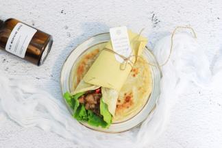 取一张饼，放入两片生菜，放入牛肉，卷起即可食用