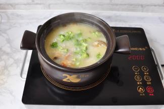 炖至十分钟左右， 这时的粥吸足了蟹的膏油，变成了金黄色，鲜香四溢，放入撕成小朵的西兰花