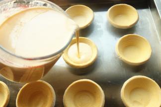 把蛋挞液注入蛋挞皮内，至9分满。