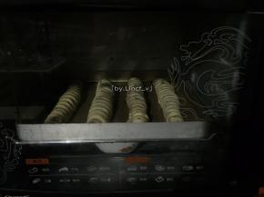 卷好的毛毛虫面段放入烤箱，底部放入热水进行发酵至2倍大
