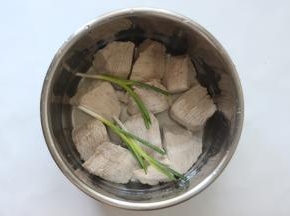 血水去掉冲洗干净猪肉后，再加入水刚好没过肉就行，再把葱放入（因为我做的是儿童肉松，所以没加太多调料，可以再加点姜或者其他大料），放在电压力锅里选择肉类功能煮熟就行