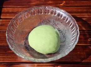 中筋面团加菠菜汁、酵母揉成软硬适中的绿色面团盖上保鲜膜进行第一次发酵