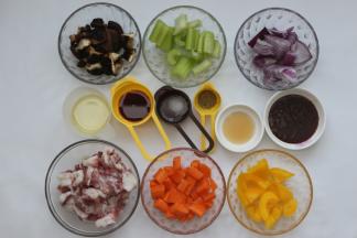 先把所有的材料准备好，洗净的黄彩椒，香菇，洋葱切成小块，西芹切成小段，胡萝卜切成小块，洗好的五花肉去皮切成块