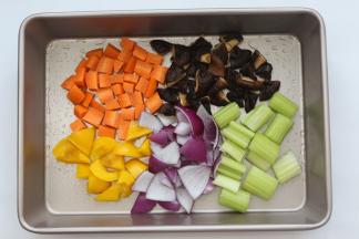 准备一个烤盘，底部刷上一层薄油，再分别把黄彩椒、香菇、胡萝卜入在烤盘上