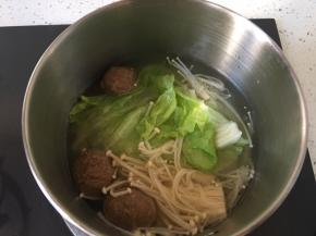 另起一锅将牛丸先煮几分钟，然后加入金针菇煮一分钟，最后加入生菜关火。