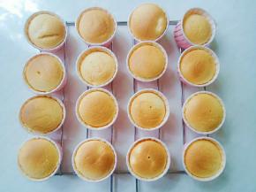 取出烤盘，在空中摔向桌面，震动出气泡。取出纸杯。