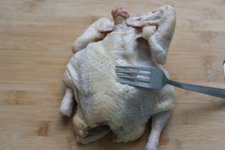 三黄鸡洗净，用叉子在鸡的表面戳洞，这样能使腌时更放味