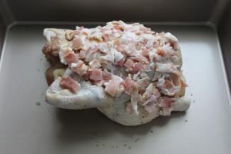 提前腌好的鸡拿出来放在深烤盘中，表面再铺上培根肉丁