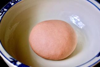 面粉中加入红曲粉和酵母搅匀后、用温水和成面团后醒发