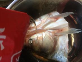 把鱼头，放入一个盆中，加入料酒；