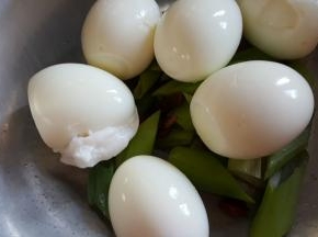 5.把去皮的鸡蛋，放在葱段上面。