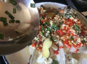 煸香的热油，淋入蒸好的鱼头中；