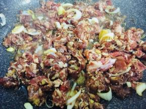 腌好的牛肉倒入锅中翻炒