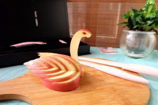 在天鹅身体中间的位置，用小水果刀挖出个小洞来，把天鹅脖子插进去，眼睛轻轻一粘就黏上了，一个漂亮的苹果天鹅就做出来了。