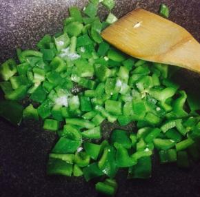 青椒洗净去籽切碎，倒入炒蛋的锅中，加入少许盐翻炒