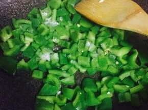 青椒洗净去籽切碎，倒入炒蛋的锅中，加入少许盐翻炒