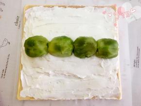 抹上淡奶油，中间高，两边薄，在中间奶油高的位置放上奇异果；