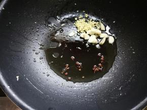 鸡蛋盛出，倒少许油，下花椒爆香，再放入姜末、蒜片。