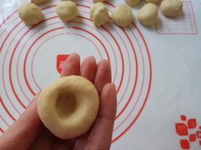 取一个面剂，左手除拇指外，四指并拢，右手大拇指在面剂底部按一个窝儿。一边向里螺旋按压，左手拇指配合，一边整理成圆锥形。