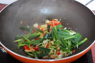 炸过茄子的油锅，爆香蒜白，虾皮、辣椒，在加蒜叶；