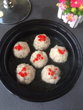 红椒撒在丸子上面盖上盖子，把辣椒煮熟。