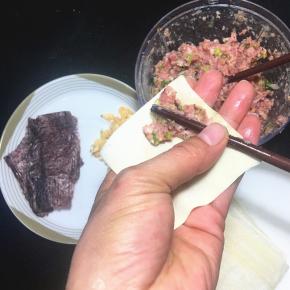 用一根筷子挑少许肉末，放在云吞皮的一角。