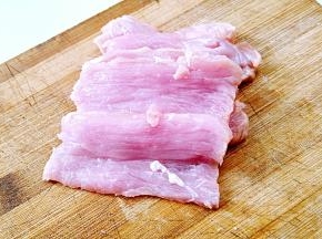 里脊肉顺着纹路切成刀背厚的片。