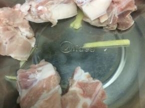 汤锅里加入适量的水，把生姜和适量的料酒放入锅中，再把大骨放入锅中，焯水去除血水