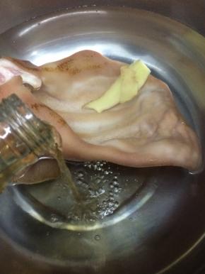 先焯一下猪耳，将买回来的猪耳处理干净，然后汤锅里加入适量水和少许料酒，在把猪耳放假锅中焯水十分钟
