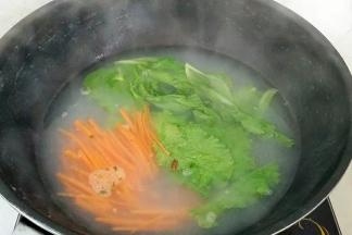 面条捞出，放入胡萝卜和生菜段生。